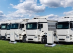 Row of electric semi trucks at charging stations
